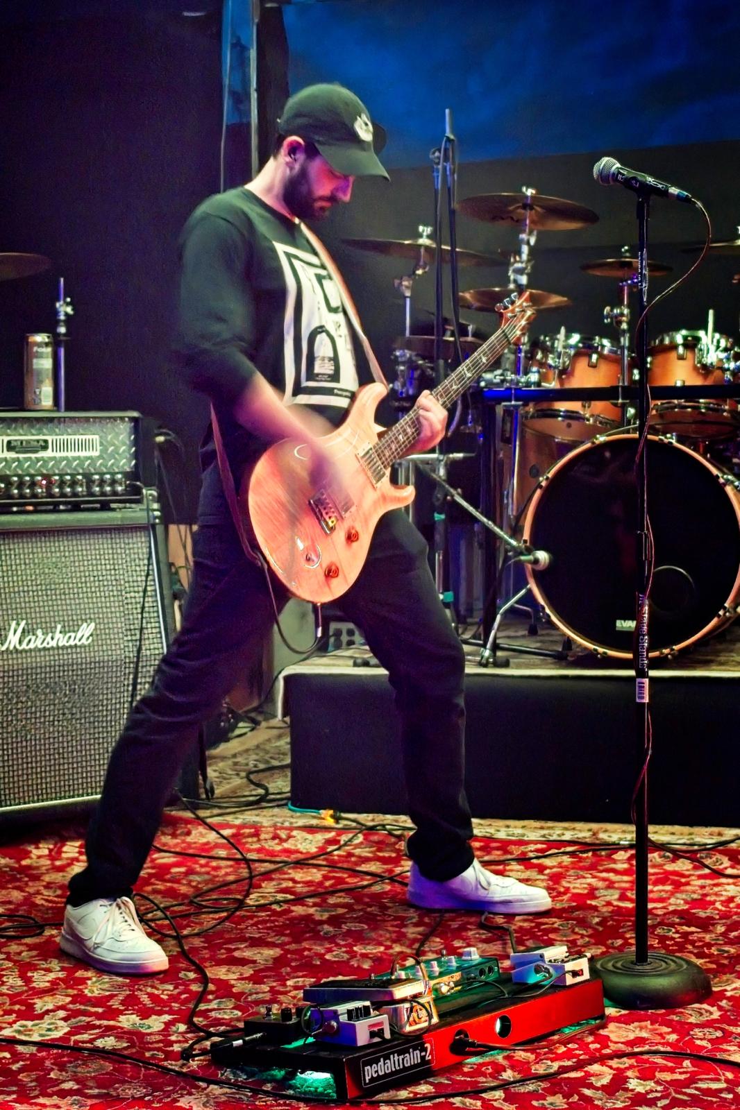 Granite guitarist live on stage in Vancouver, Marshall stack and drum kit behind