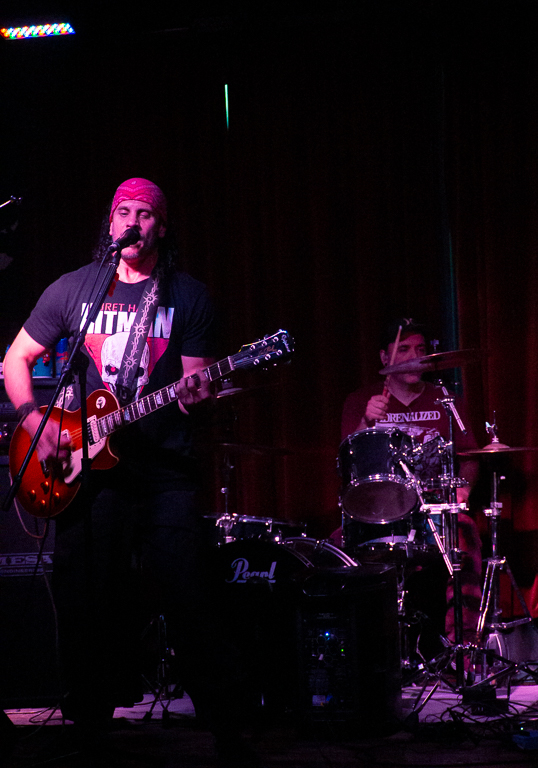 Lift the Anchor guitar and drums under the stage lights at the Portside Pub